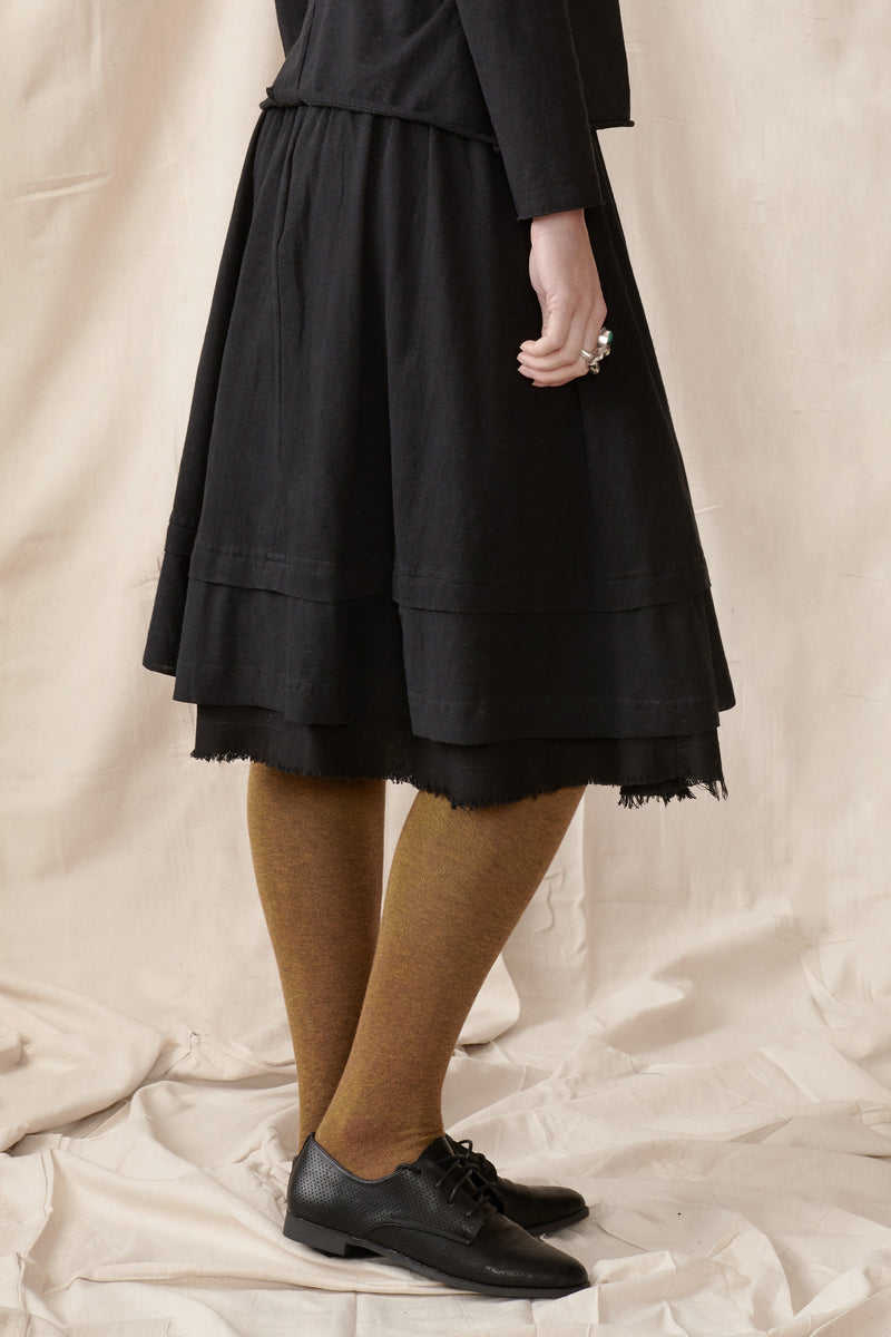 Side of black organic raw hem skirt